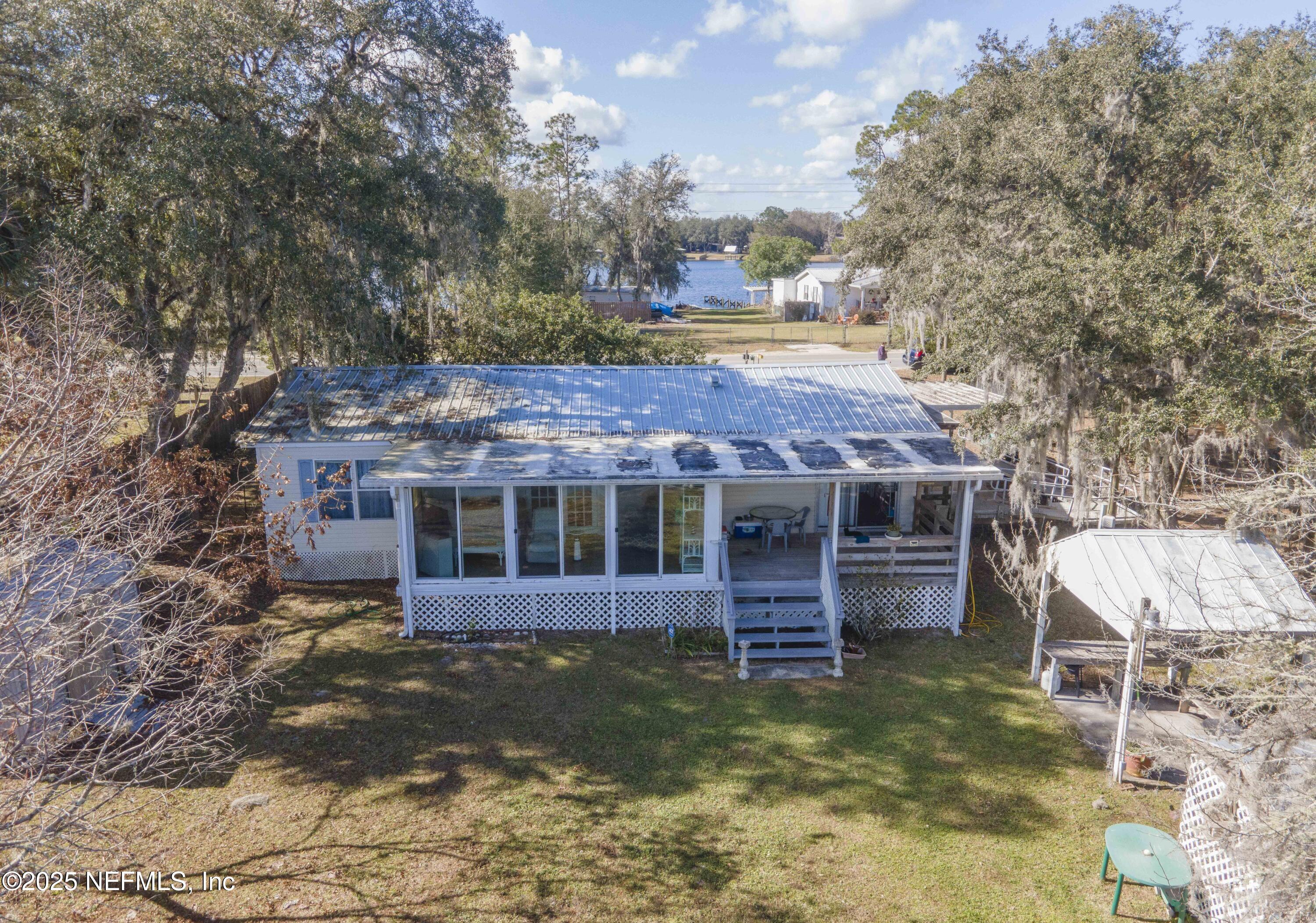 222 Kitty Avenue Interlachen, FL 32148 - Photo 7 of 34 a view of a house with a yard potted plants and large tree