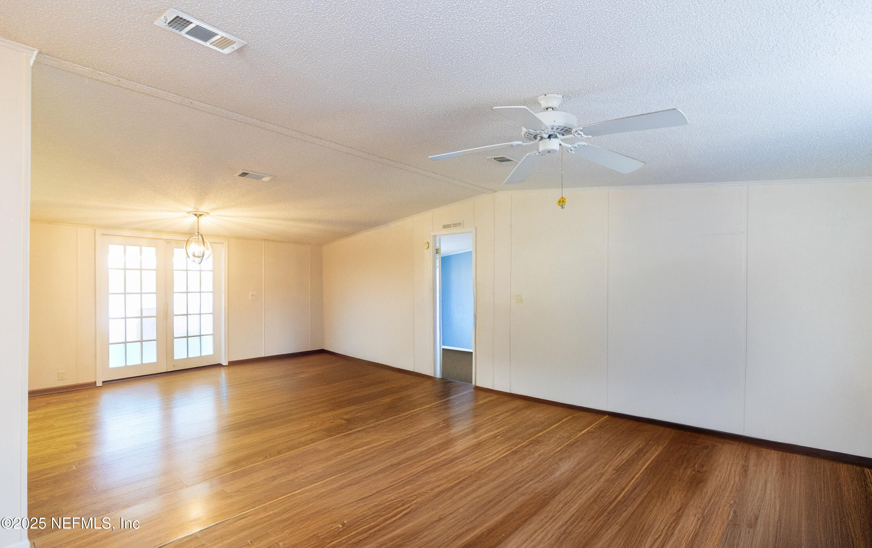 222 Kitty Avenue Interlachen, FL 32148 - Photo 10 of 34 an empty room with wooden floor and windows