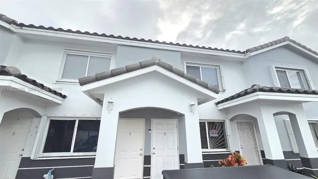 a view of a white house with large windows