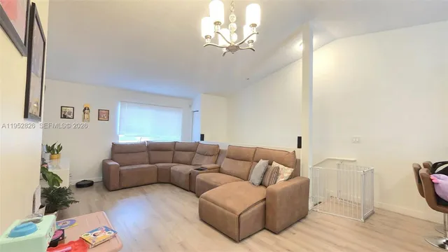 a living room with furniture a couch and a chandelier
