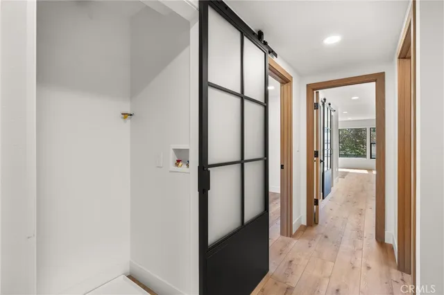 a view of a hallway with furniture and a window