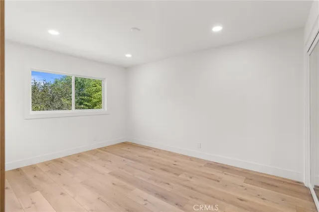 an empty room with wooden floor and window