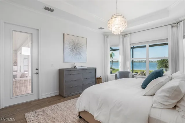 a bedroom with a large bed and a chandelier