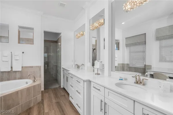 a bathroom with double vanity sinks double vanity tub and a shower