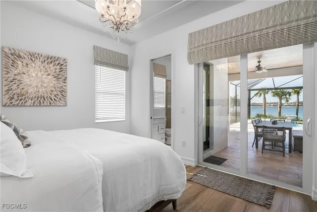 a bedroom with a large bed and a chandelier