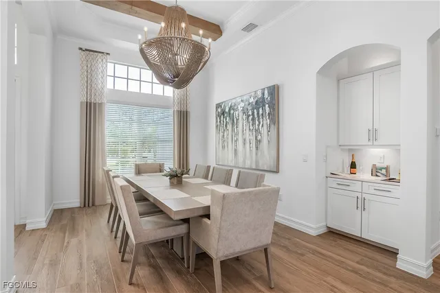 a view of a dining room with furniture a chandelier and wooden floor