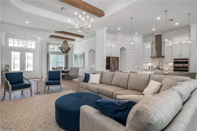 a living room with furniture kitchen and a chandelier
