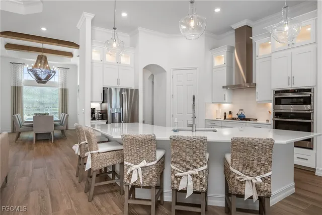 a kitchen with stainless steel appliances granite countertop a kitchen island a stove a table and chairs in it