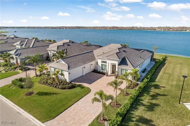 an aerial view of a house with a garden and lake view