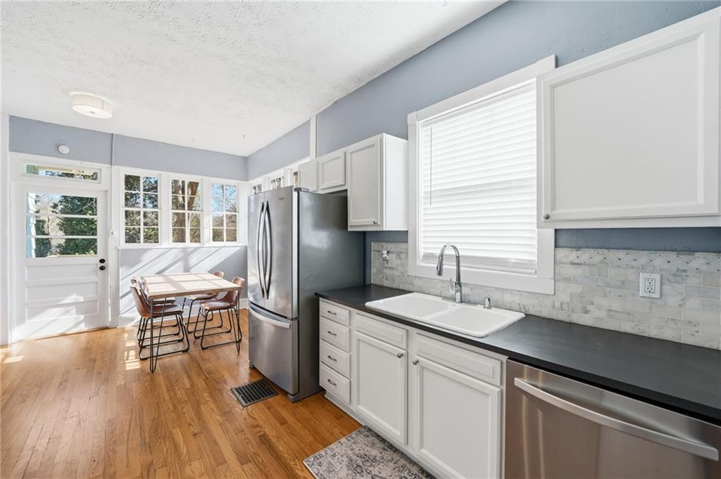 1420 Sylvan Road Southwest Atlanta, GA 30310 - Photo 16 of 43 a kitchen with stainless steel appliances granite countertop a refrigerator a sink dishwasher a stove and white countertops with wooden floor