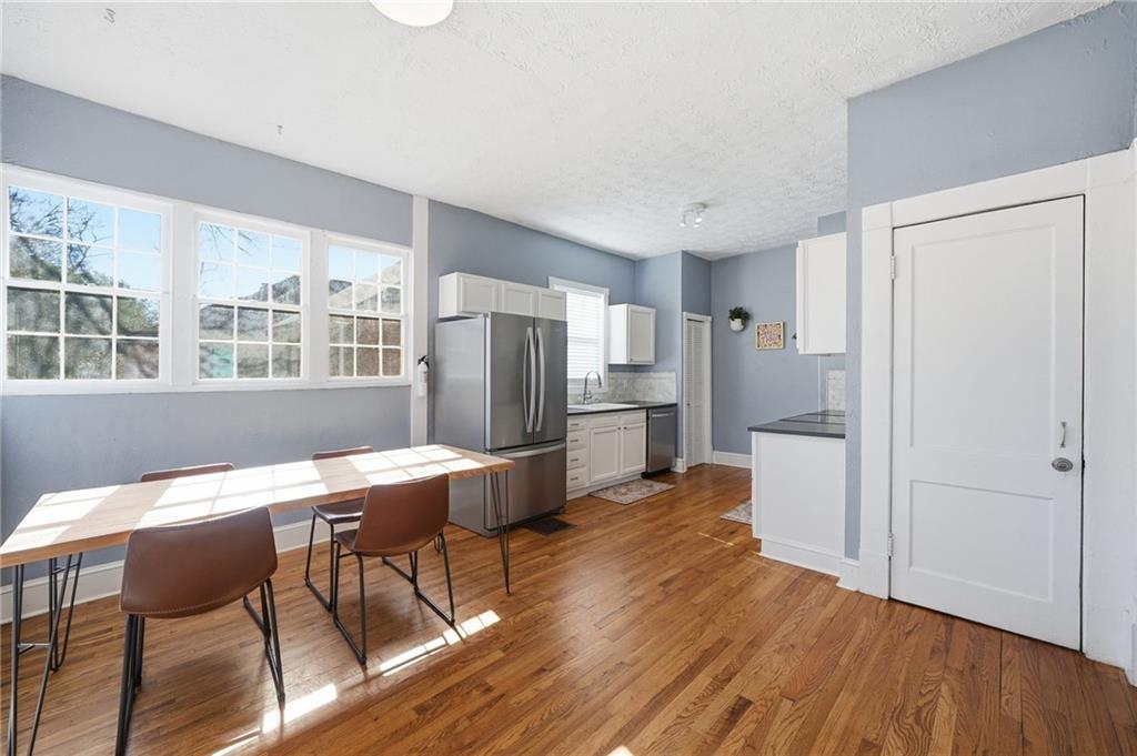 1420 Sylvan Road Southwest Atlanta, GA 30310 - Photo 18 of 51 a kitchen with stainless steel appliances a dining table chairs refrigerator and sink