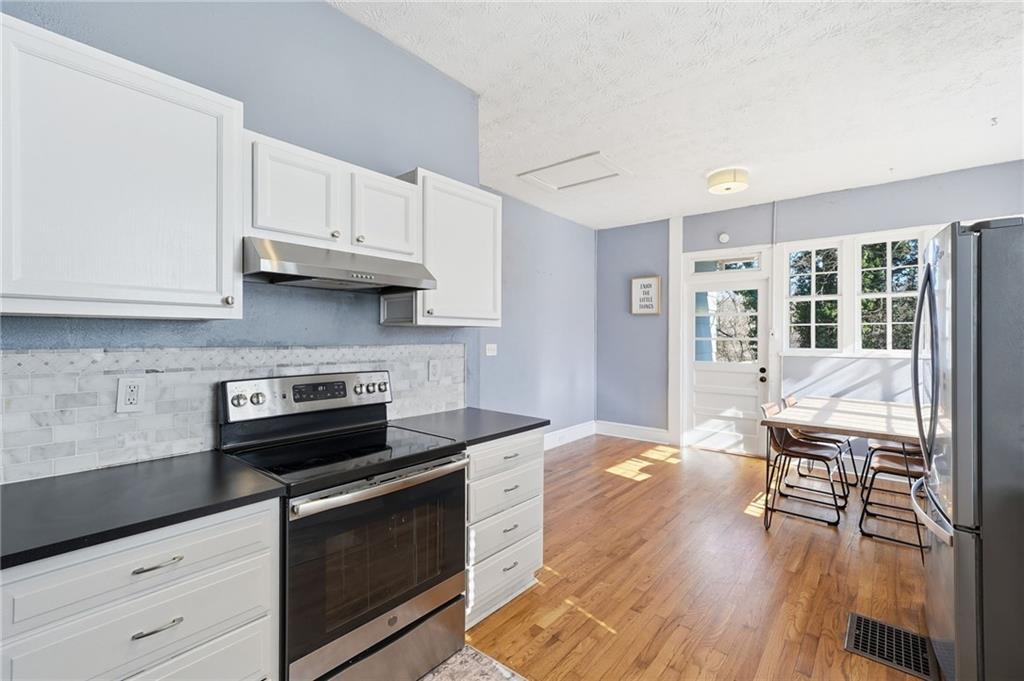 1420 Sylvan Road Southwest Atlanta, GA 30310 - Photo 23 of 51 a kitchen with granite countertop a stove and a wooden floors