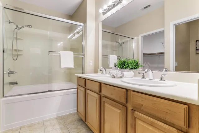 a bathroom with a double vanity sink mirror double and shower