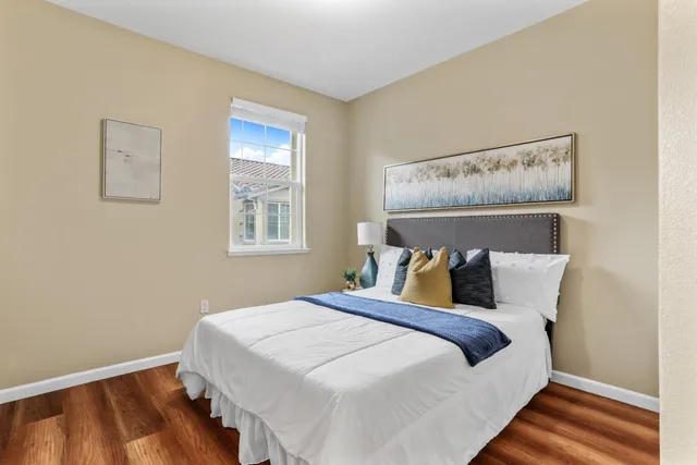 a large bed sitting in a bedroom next to a window