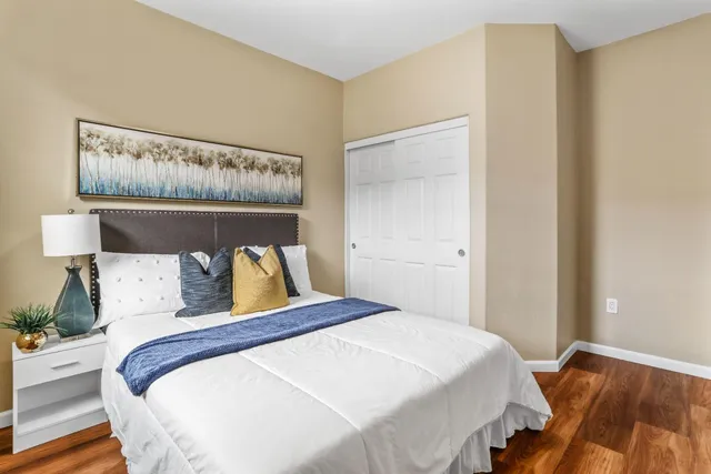 a bedroom with a bed and wooden floor