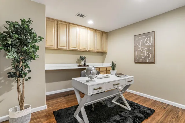 a view of a workspace with furniture and wooden floor