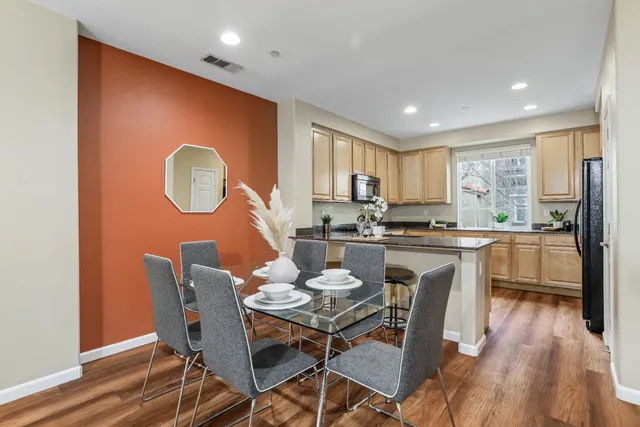 a kitchen with a table chairs a sink dishwasher a dining table and chairs with wooden floor