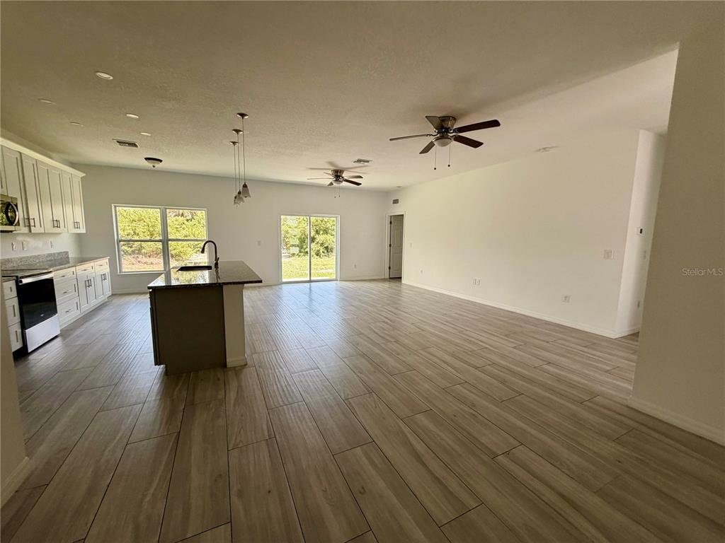 14142 Appleton Boulevard Port Charlotte, FL 33981 - Photo 4 of 26 an empty room with wooden floor and windows