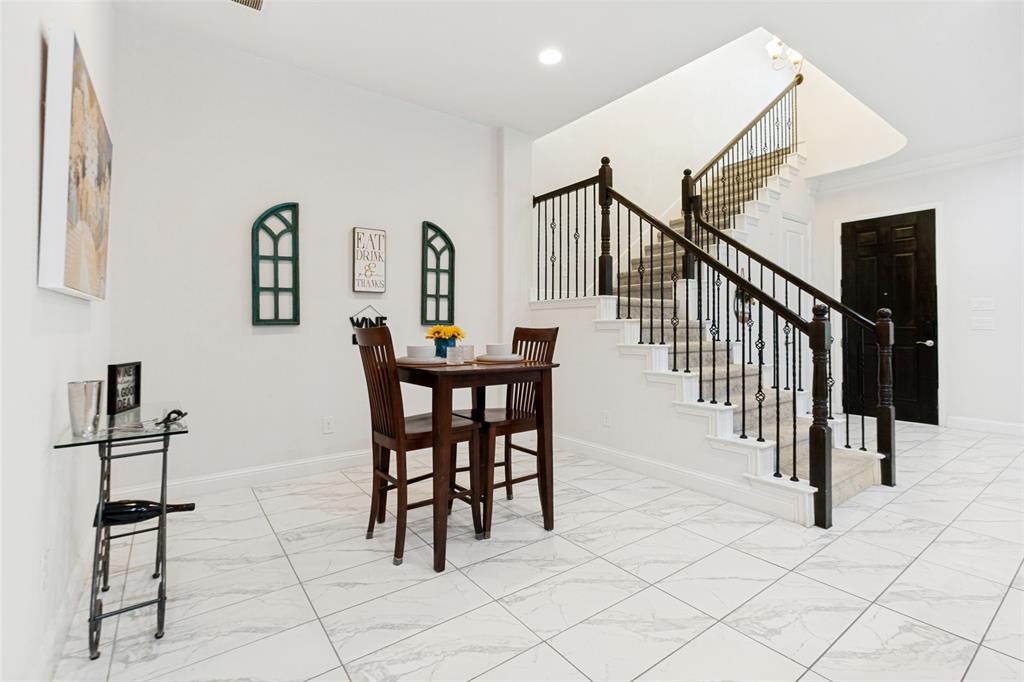 605 Ansley Way Allen, TX 75013 - Photo 11 of 28 Open concept area featuring a prominent staircase with dark wood newel posts and metal balusters