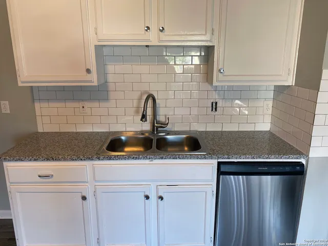 a kitchen with stainless steel appliances granite countertop a sink dishwasher a refrigerator and cabinets