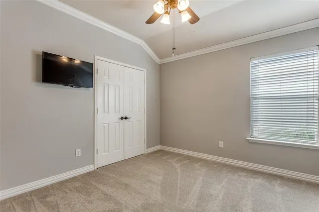a view of an empty room with a flat screen tv and a window