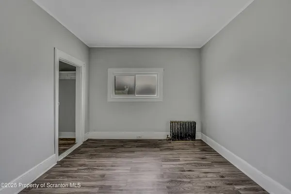 a view of a livingroom with wooden floor and a window