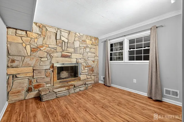 wooden floor fireplace and windows in an empty room
