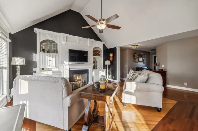 a living room with furniture a fireplace and a flat screen tv