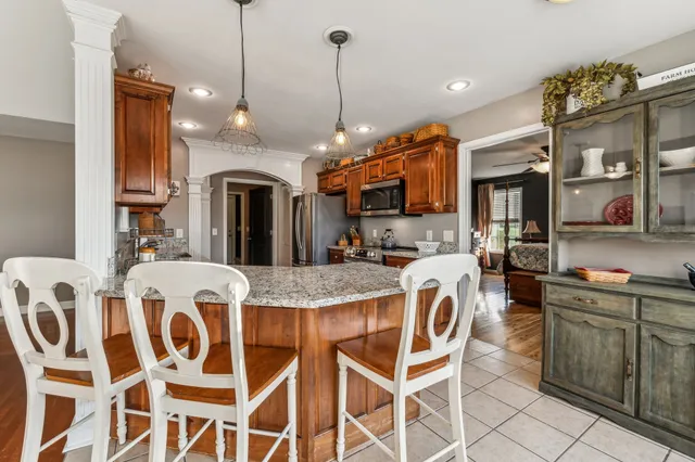 a view of a dining room and livingroom with furniture wooden floor a chandelier