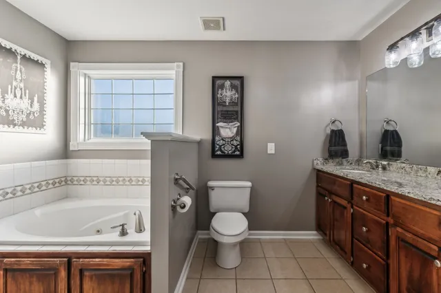 a bathroom with a granite countertop sink a toilet and a bathtub