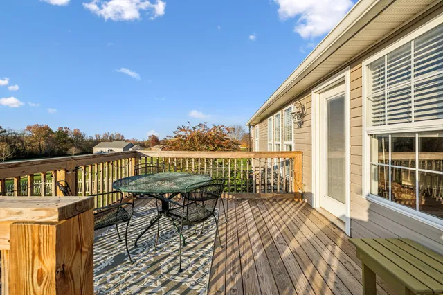 a balcony with wooden floor table and chairs