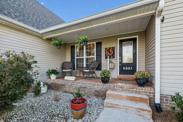 a view of a backyard with table and chairs potted plants
