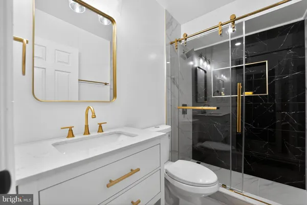 a bathroom with a sink toilet vanity and shower