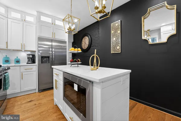 a kitchen with a sink a refrigerator and chandelier