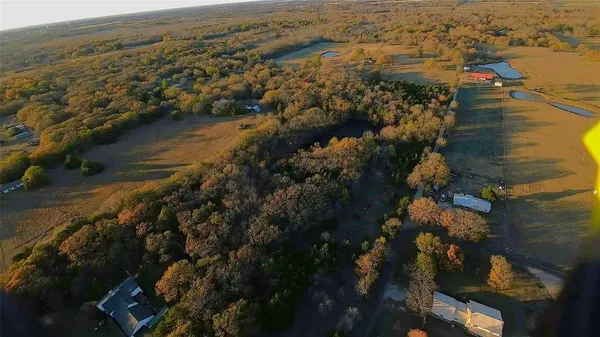 an aerial view of ocean and residential houses with outdoor space