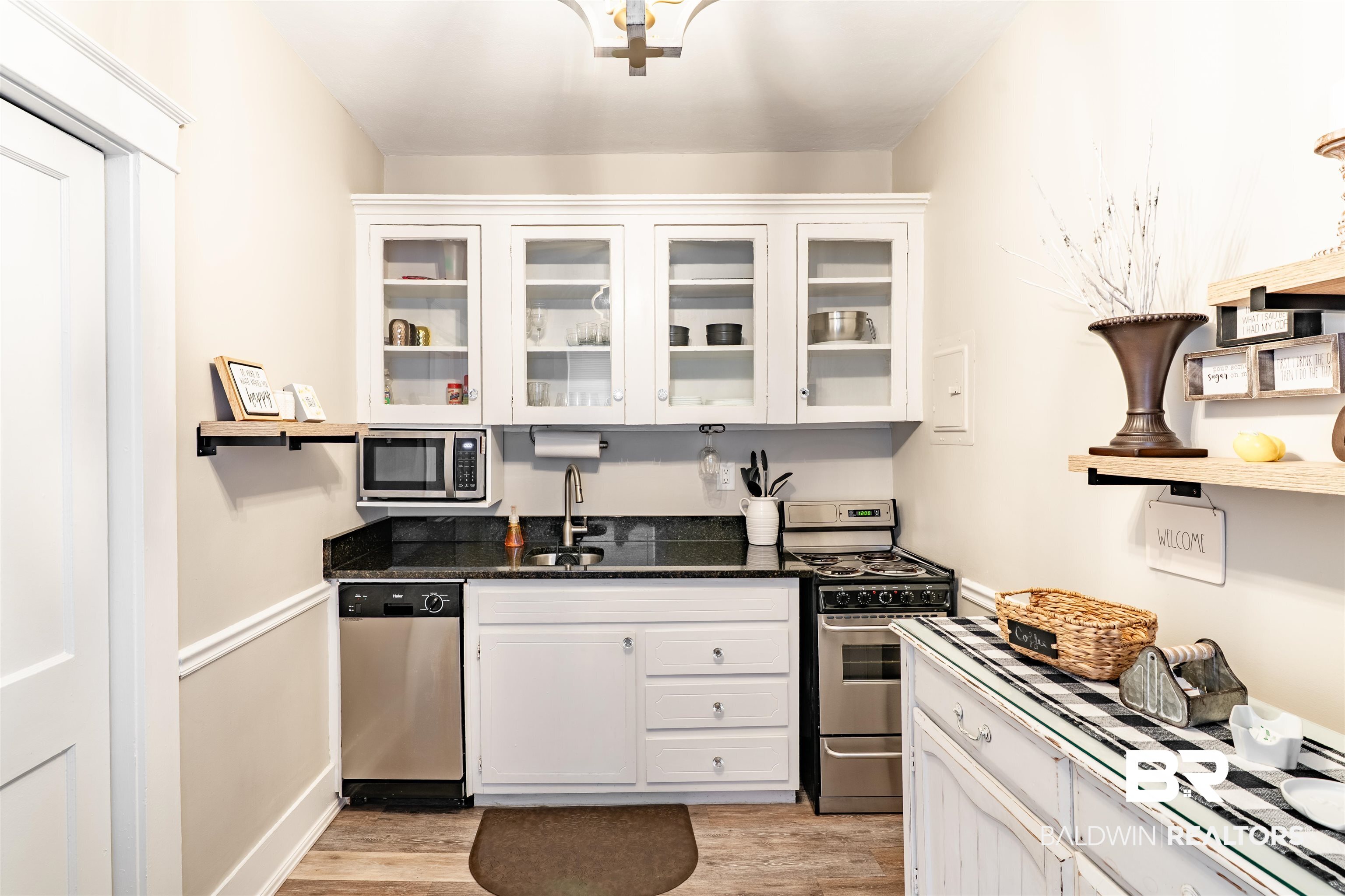 1600 Government Street, Unit 3F Mobile, AL 36604 - Photo 15 of 18 Kitchen with appliances with stainless steel finishes, light wood finished floors, white cabinets, and glass insert cabinets