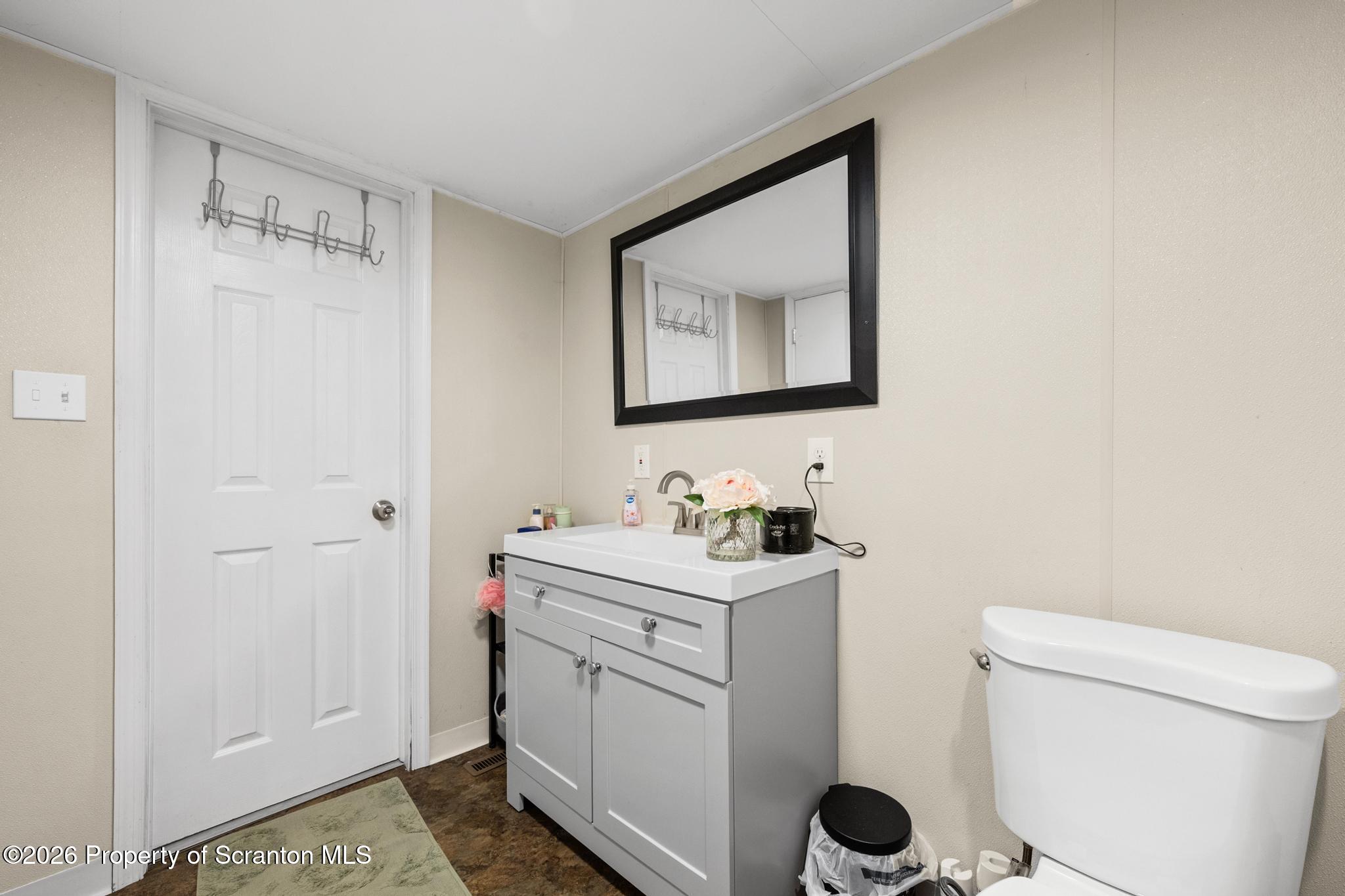 1227 Bennett Street Old Forge, PA 18518 - Photo 15 of 26 a bathroom with a toilet sink vanity and mirror
