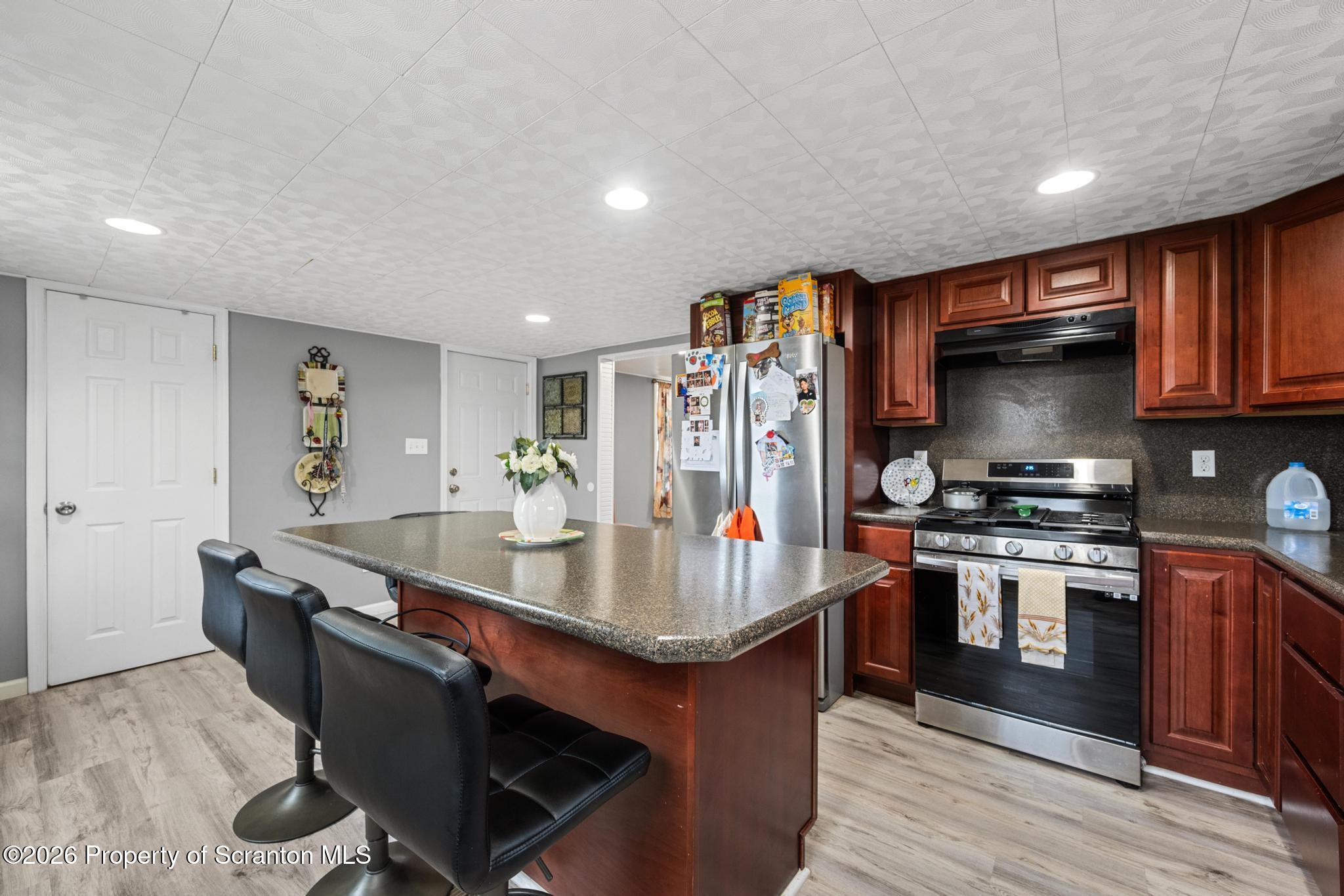 1227 Bennett Street Old Forge, PA 18518 - Photo 6 of 26 a kitchen with stainless steel appliances granite countertop a sink stove and refrigerator