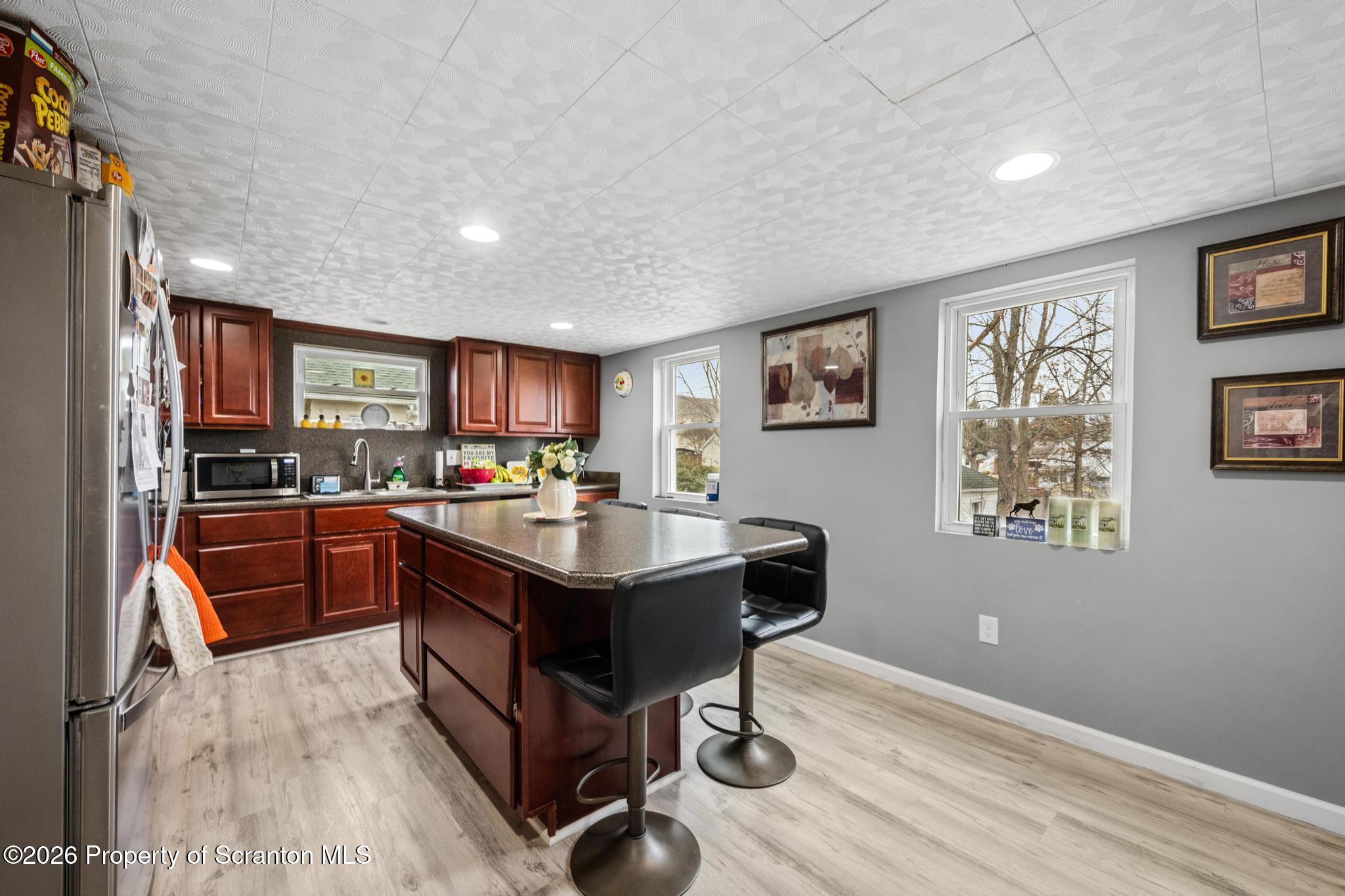 1227 Bennett Street Old Forge, PA 18518 - Photo 7 of 26 a kitchen with stainless steel appliances granite countertop a refrigerator a sink dishwasher a stove with wooden cabinets and floor
