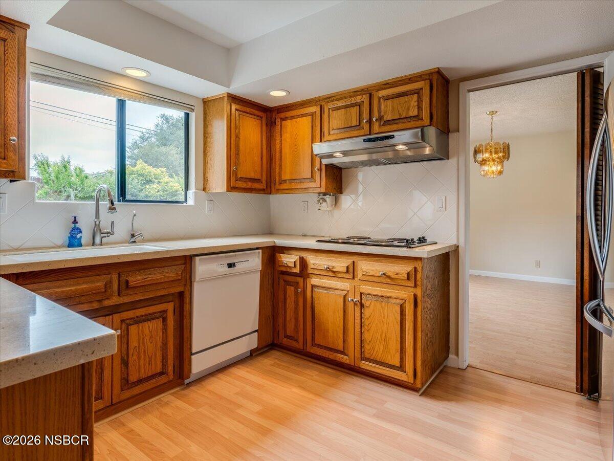360 Tallyho Road Santa Maria, CA 93455 - Photo 19 of 72 a kitchen with stainless steel appliances granite countertop a refrigerator a sink dishwasher a stove and white countertops with wooden floor