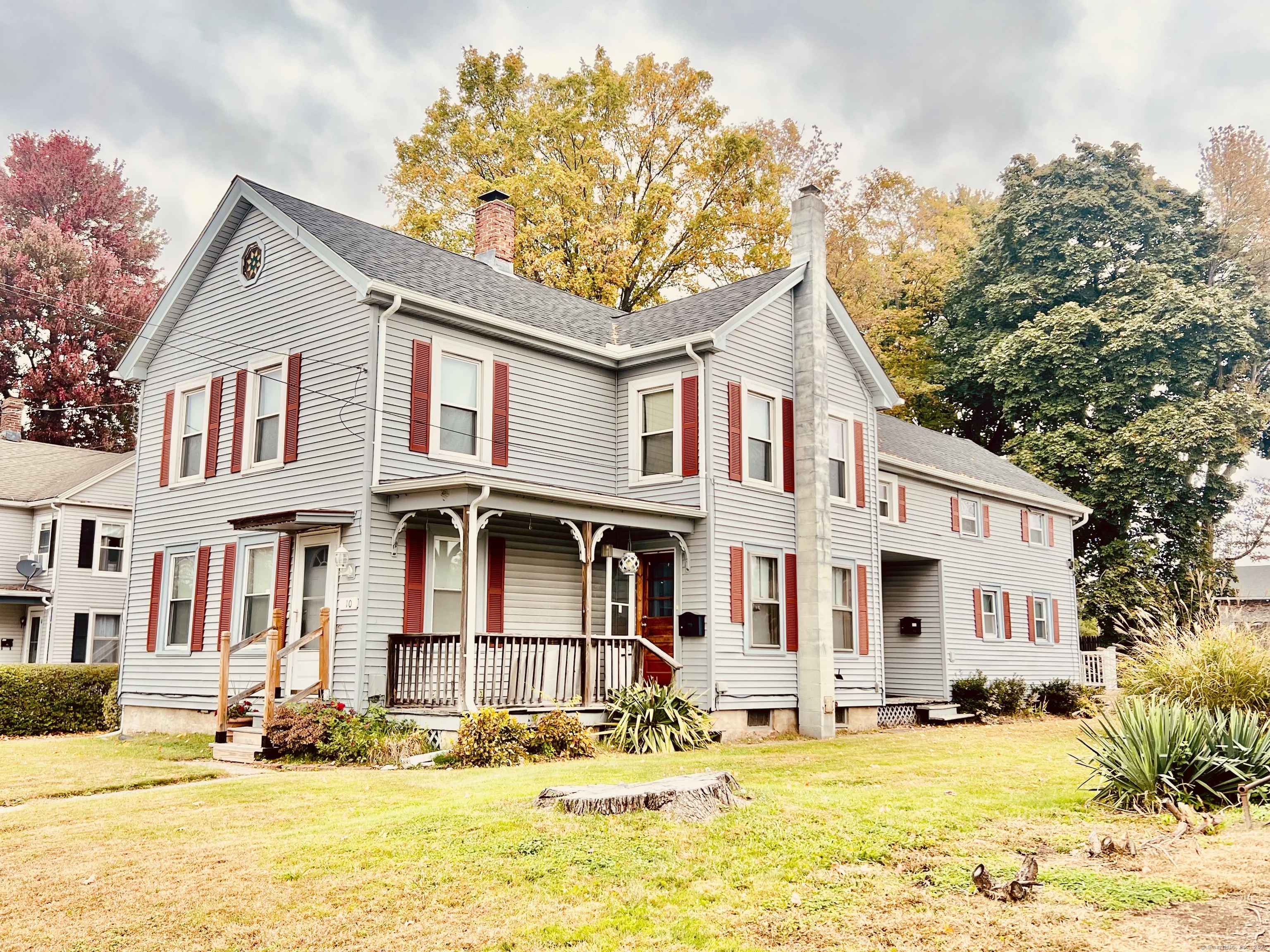 a view of a white house with a large tree in front of it