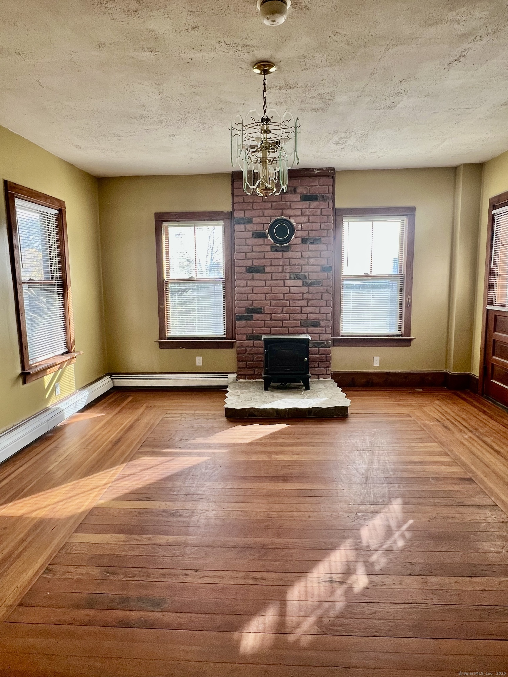 10 Russell Street Enfield, CT 06082 - Photo 2 of 12 a view of a livingroom with a fireplace a chandelier and windows