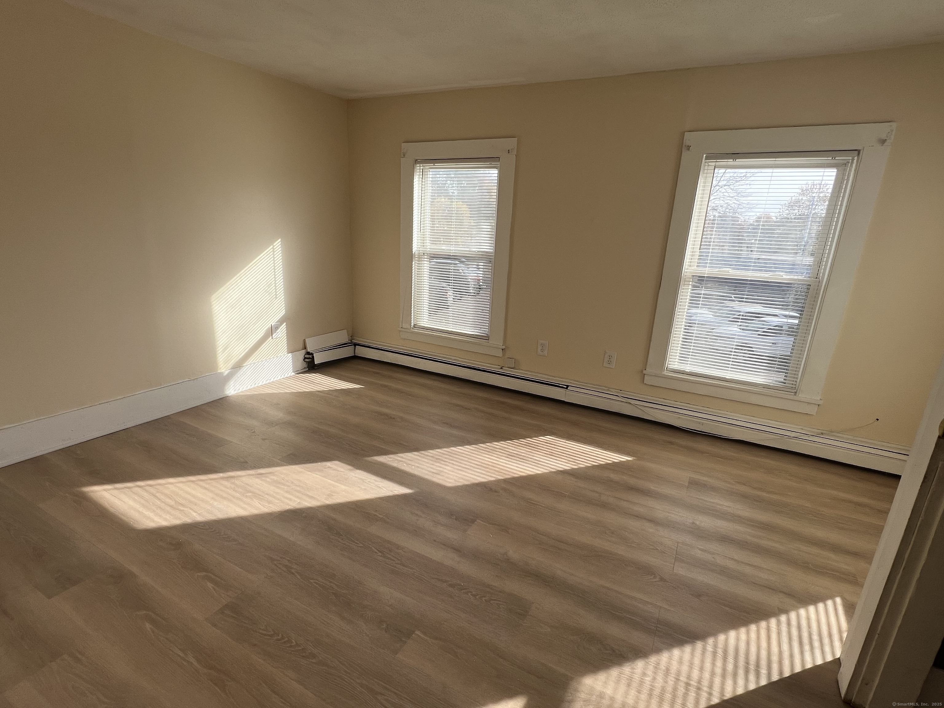 10 Russell Street Enfield, CT 06082 - Photo 7 of 12 an empty room with wooden floor and windows