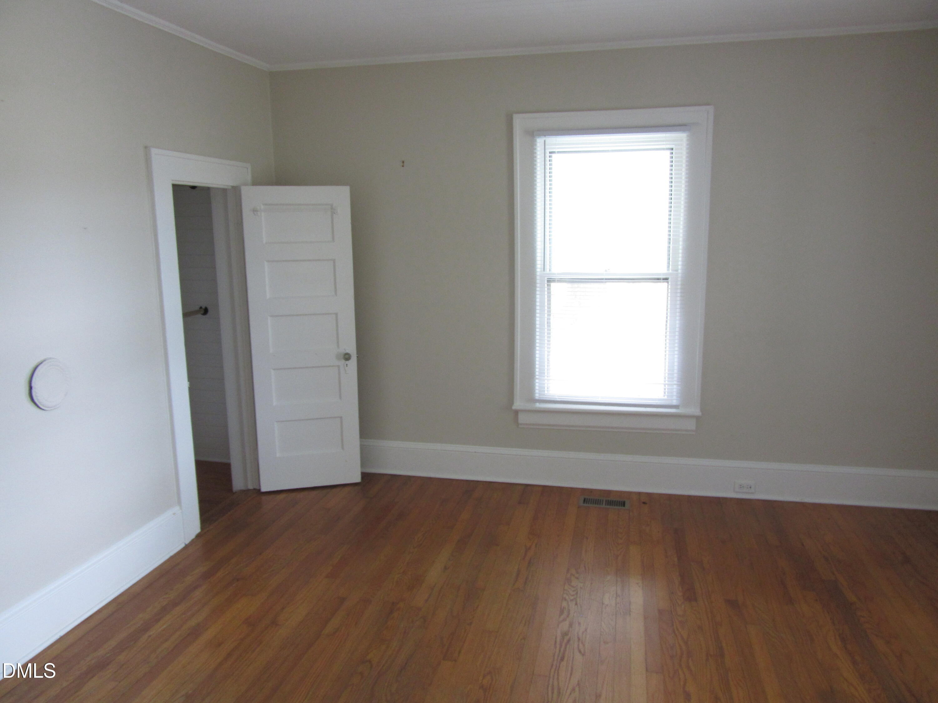 545 Main Street Bunn, NC 27508 - Photo 5 of 13 an empty room with wooden floor and windows