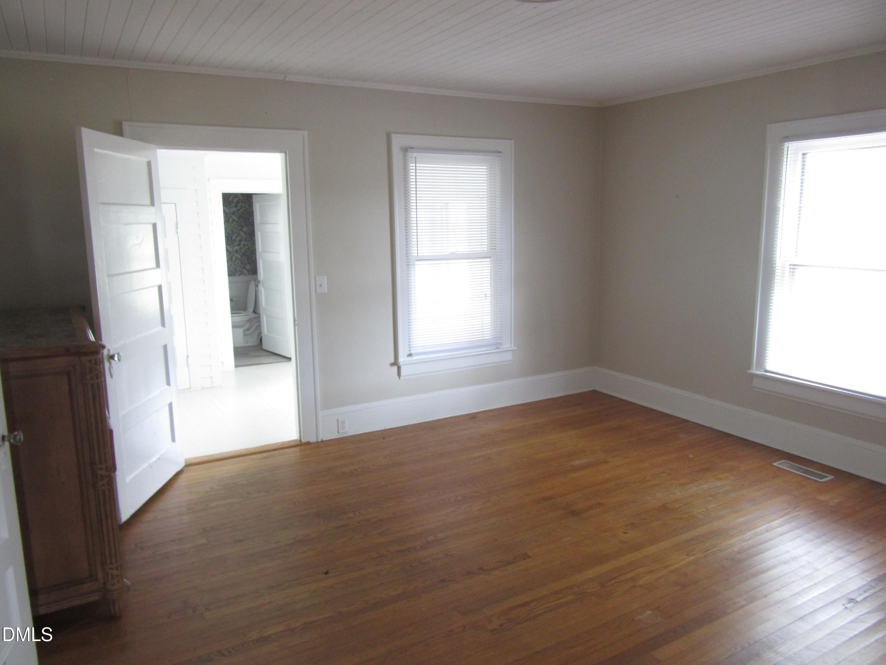 545 Main Street Bunn, NC 27508 - Photo 6 of 13 an empty room with wooden floor and windows