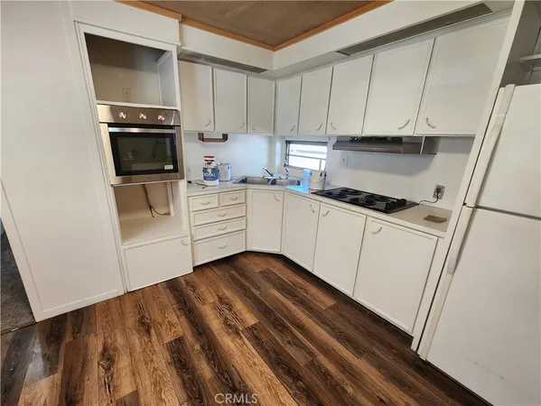a kitchen with granite countertop white cabinets and white appliances