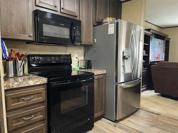a kitchen with granite countertop wooden cabinets stainless steel appliances and a counter space