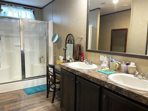 a bathroom with a granite countertop sink a mirror and a shower