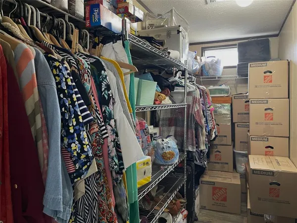 a view of walk in closet with clothes