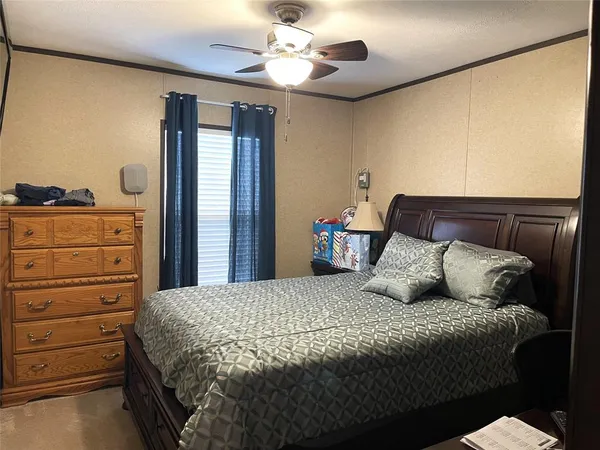 a bedroom with a large bed and a chandelier